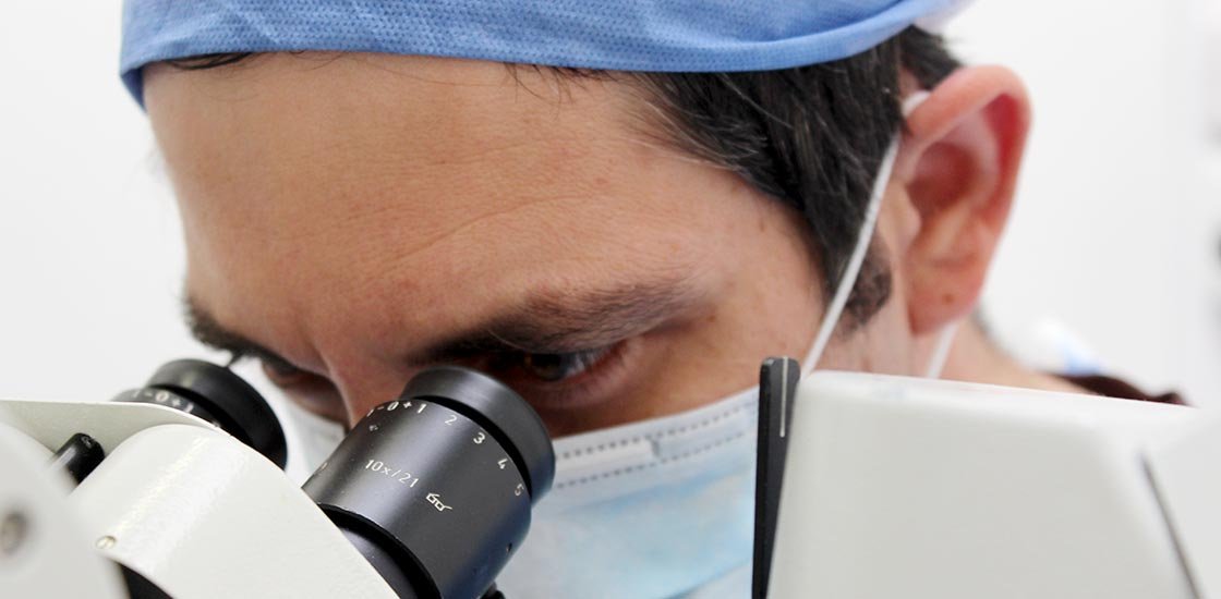 Dr Tamir Spiegel looking through an operating microscope